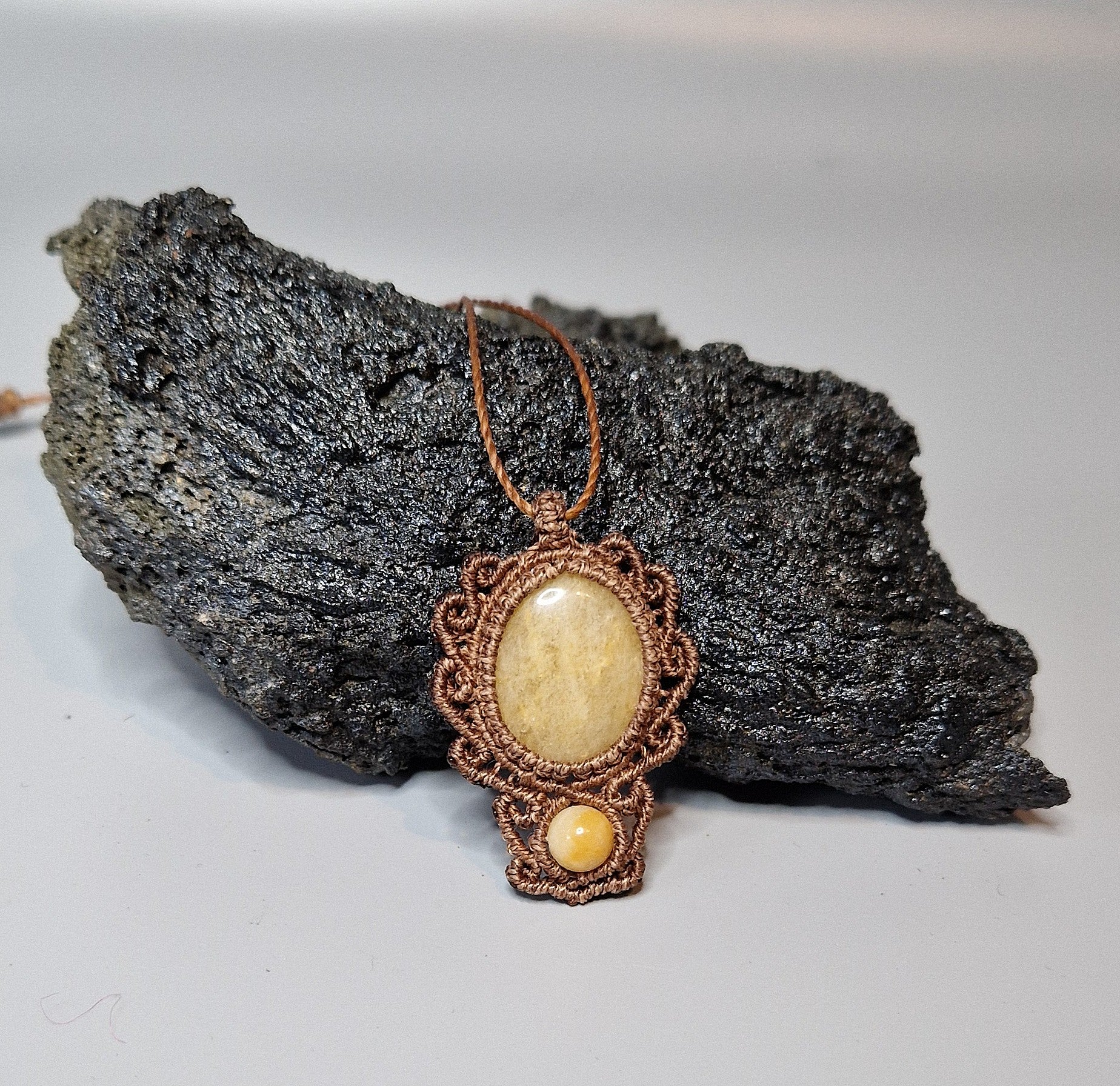 Pendant with a yellow stone on a dark rock background