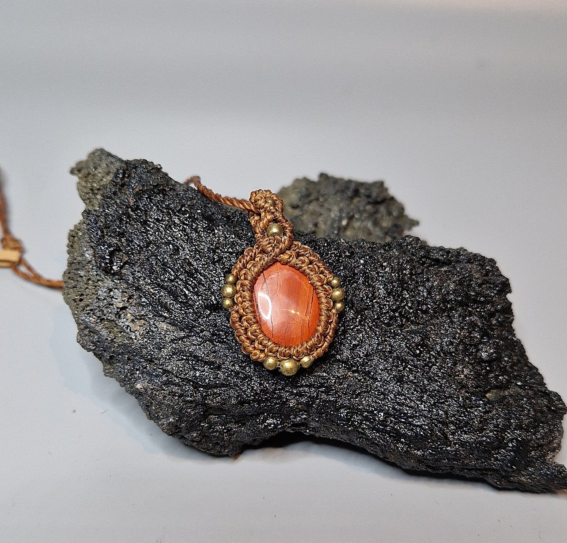 Jewelry with a red stone and gold accents on a dark rock background