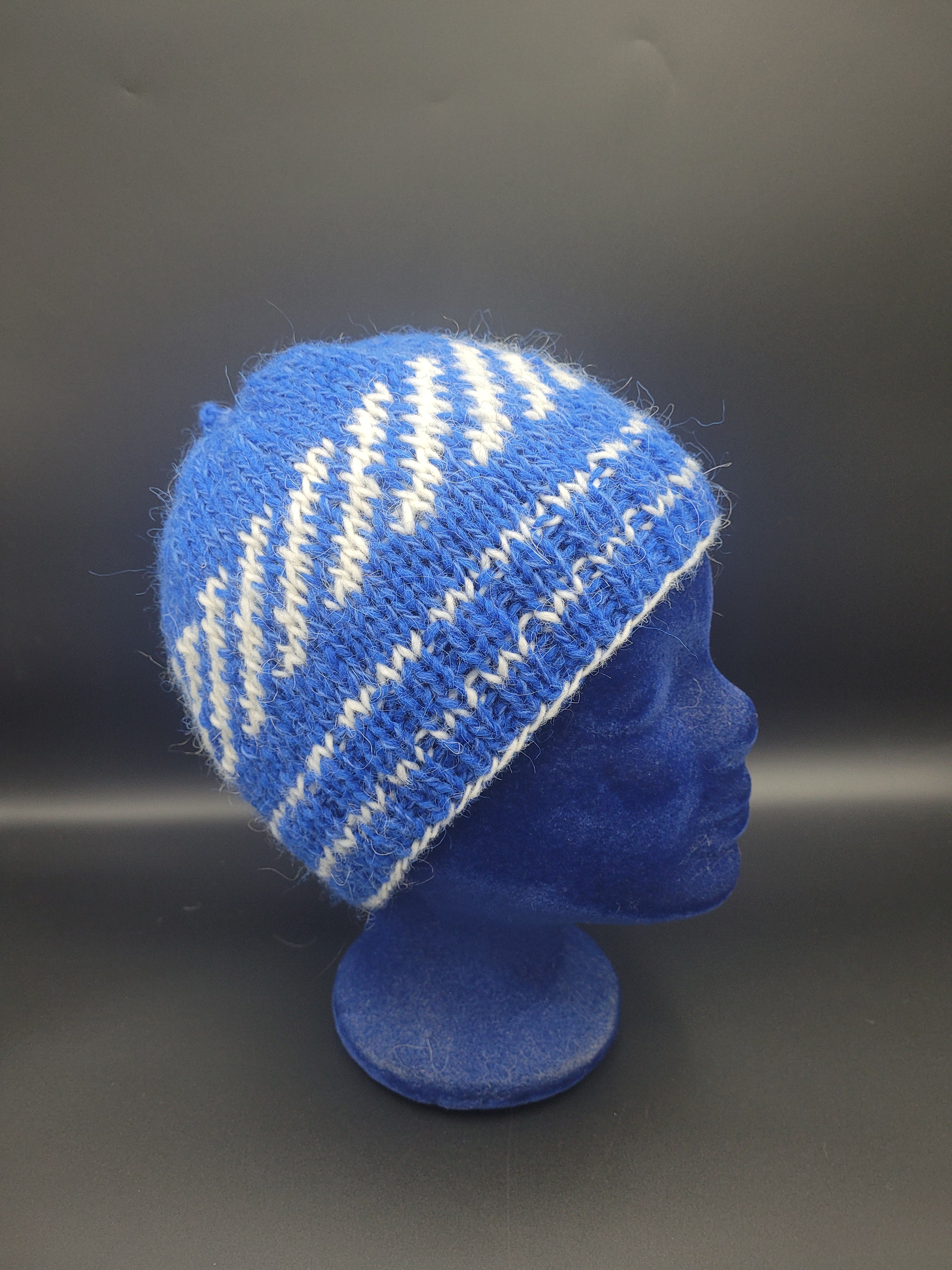 Blue knitted hat with white pattern on a dark background