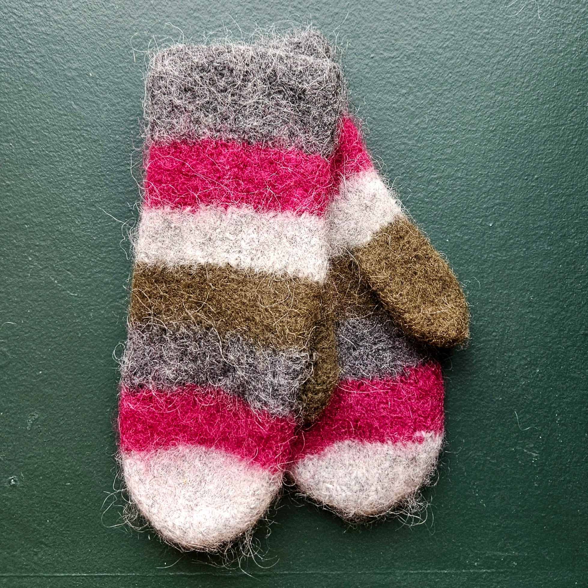 Striped mittens on a green background