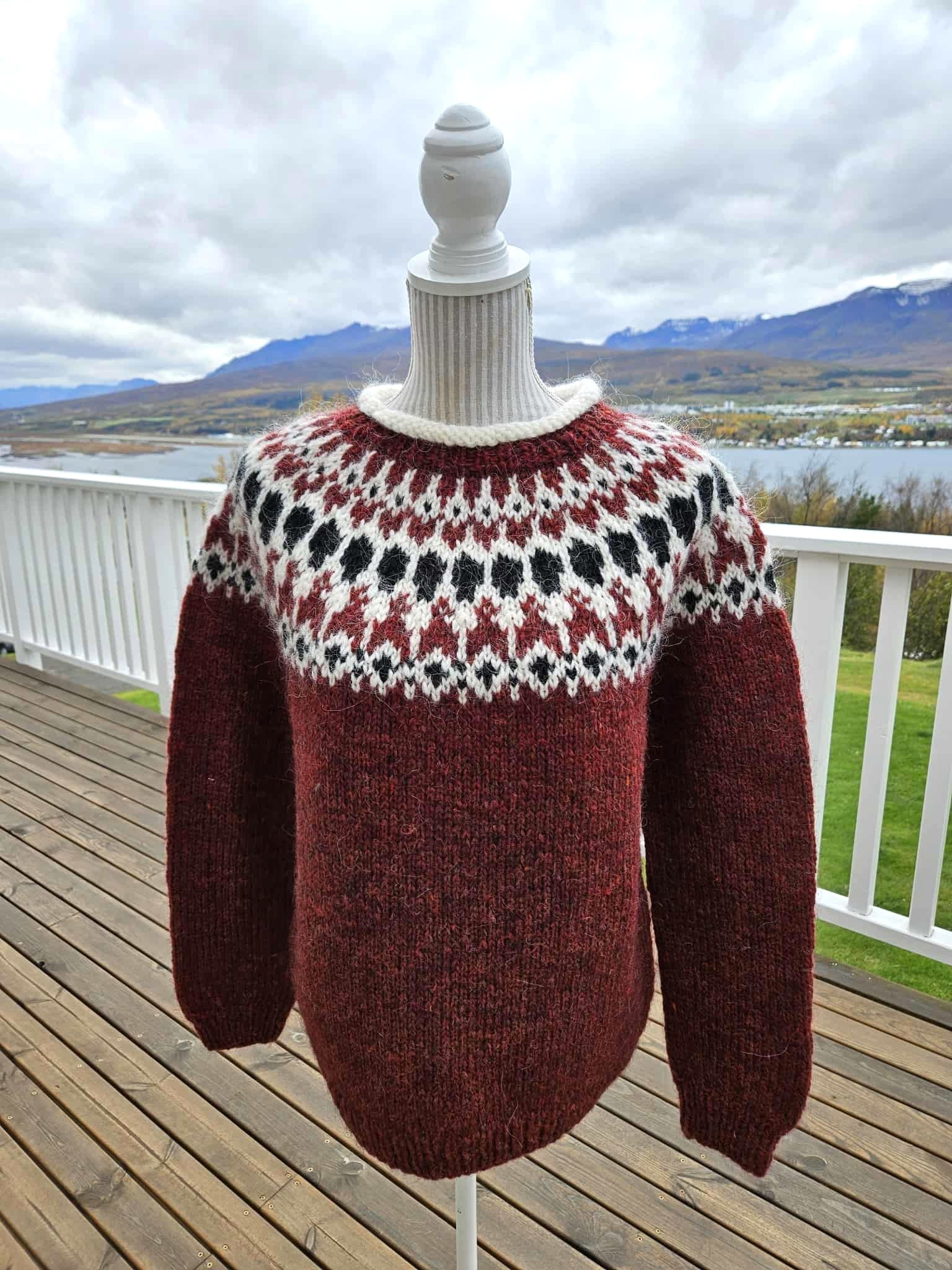 Knitted sweater with a pattern on a mannequin against a scenic background