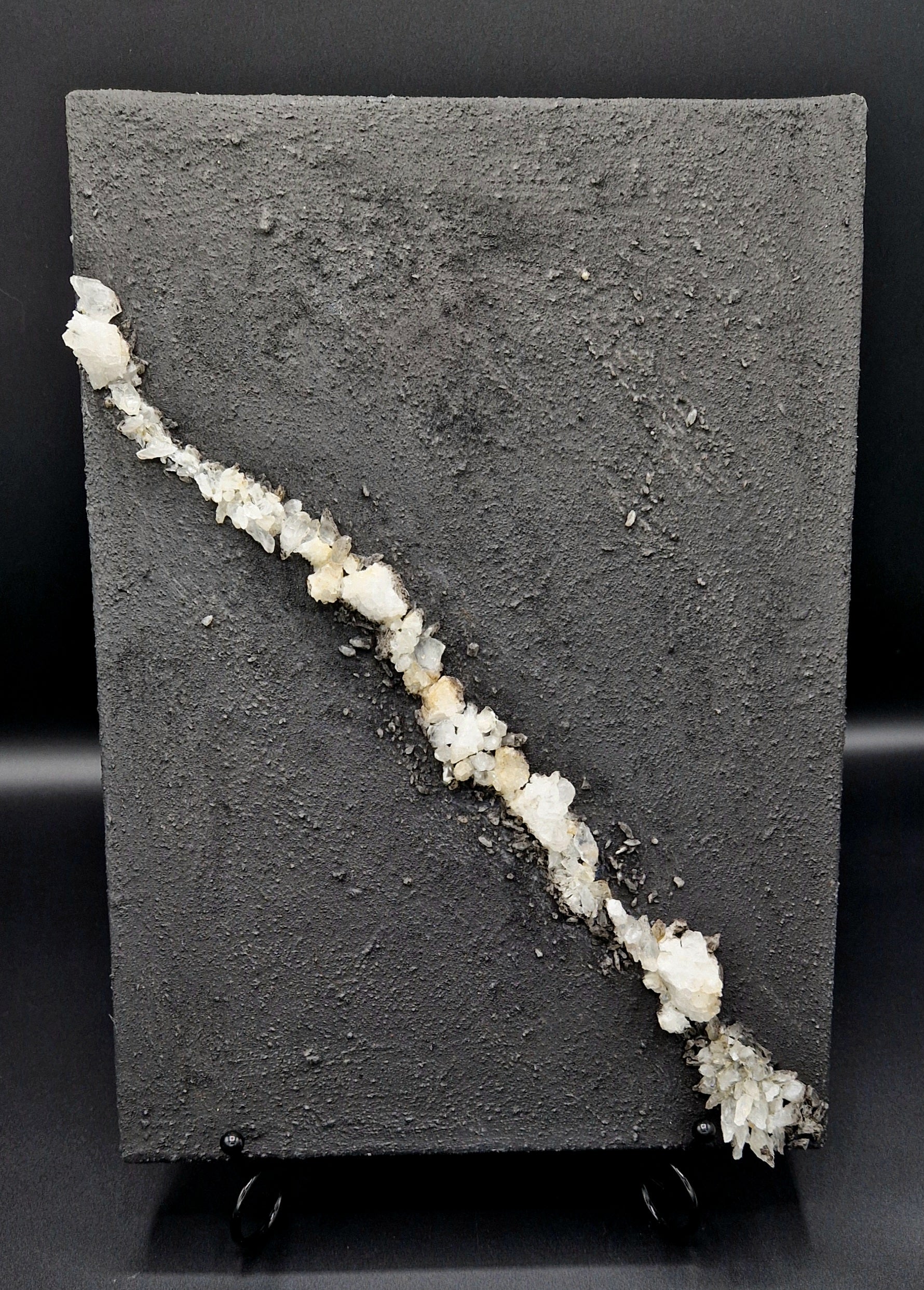 Painting depicting a "vein" made out of crystal on a dark textured background.