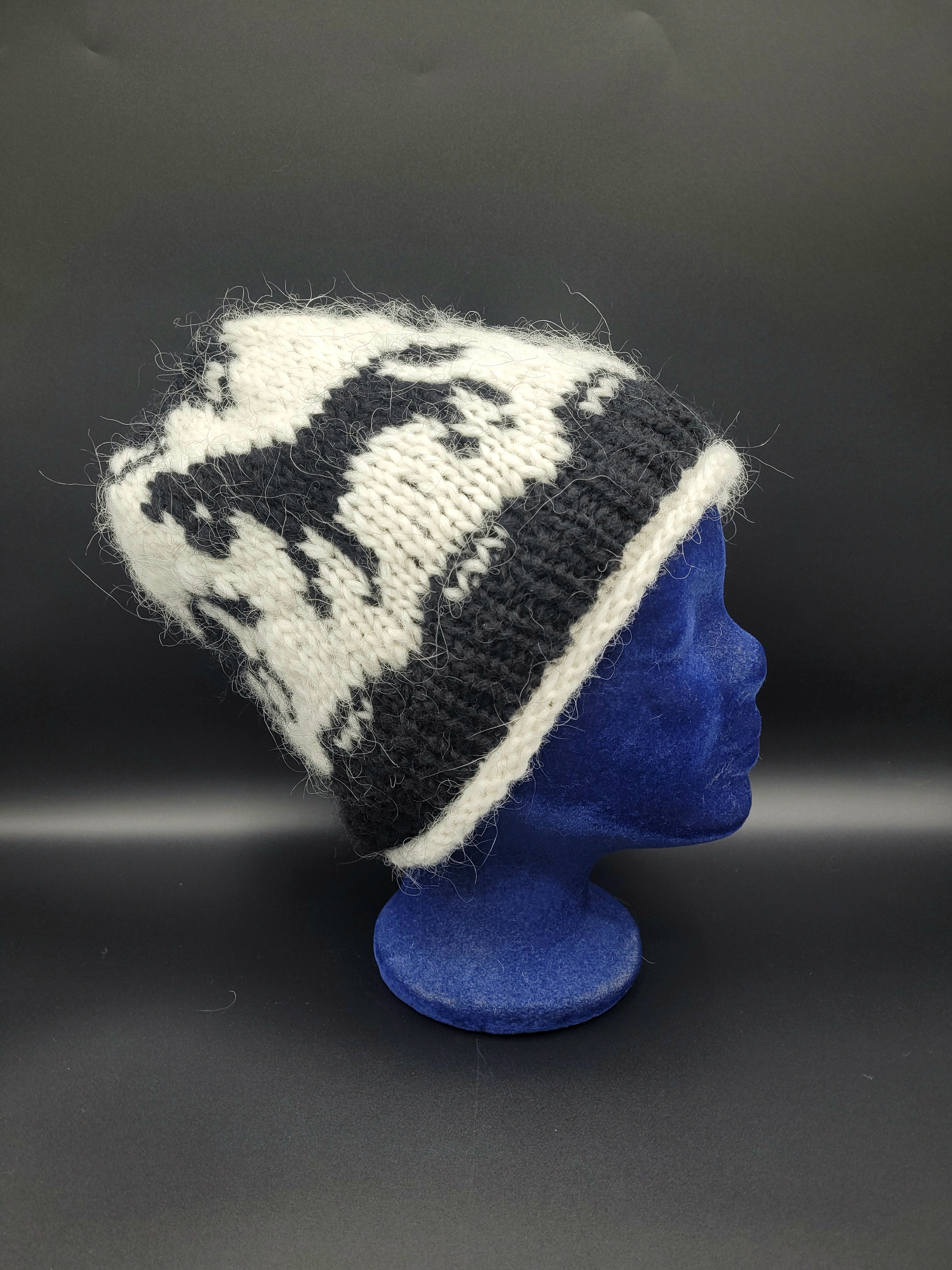 Knitted beanie with a horse pattern on a blue mannequin head against a gray background