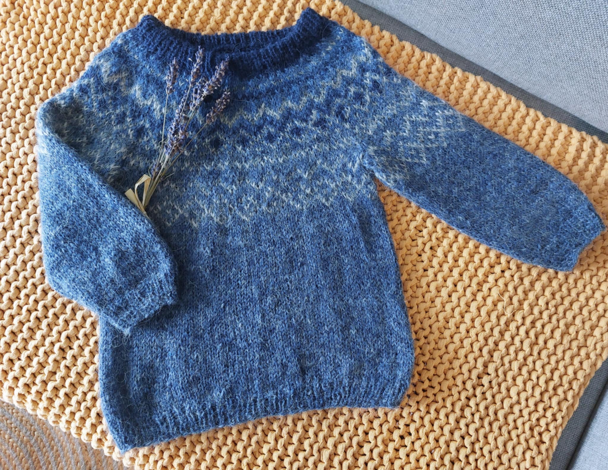 Hand-knit Icelandic wool sweater featuring a traditional Nordic pattern on a textured surface