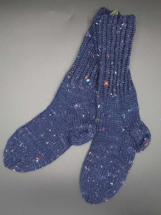 Pair of blue knitted socks on a gray background
