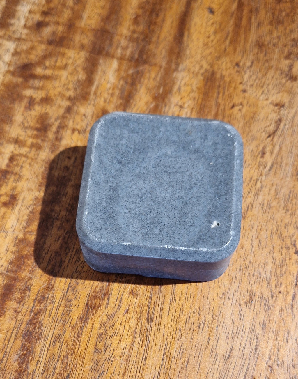 Square gray soap on a wooden surface