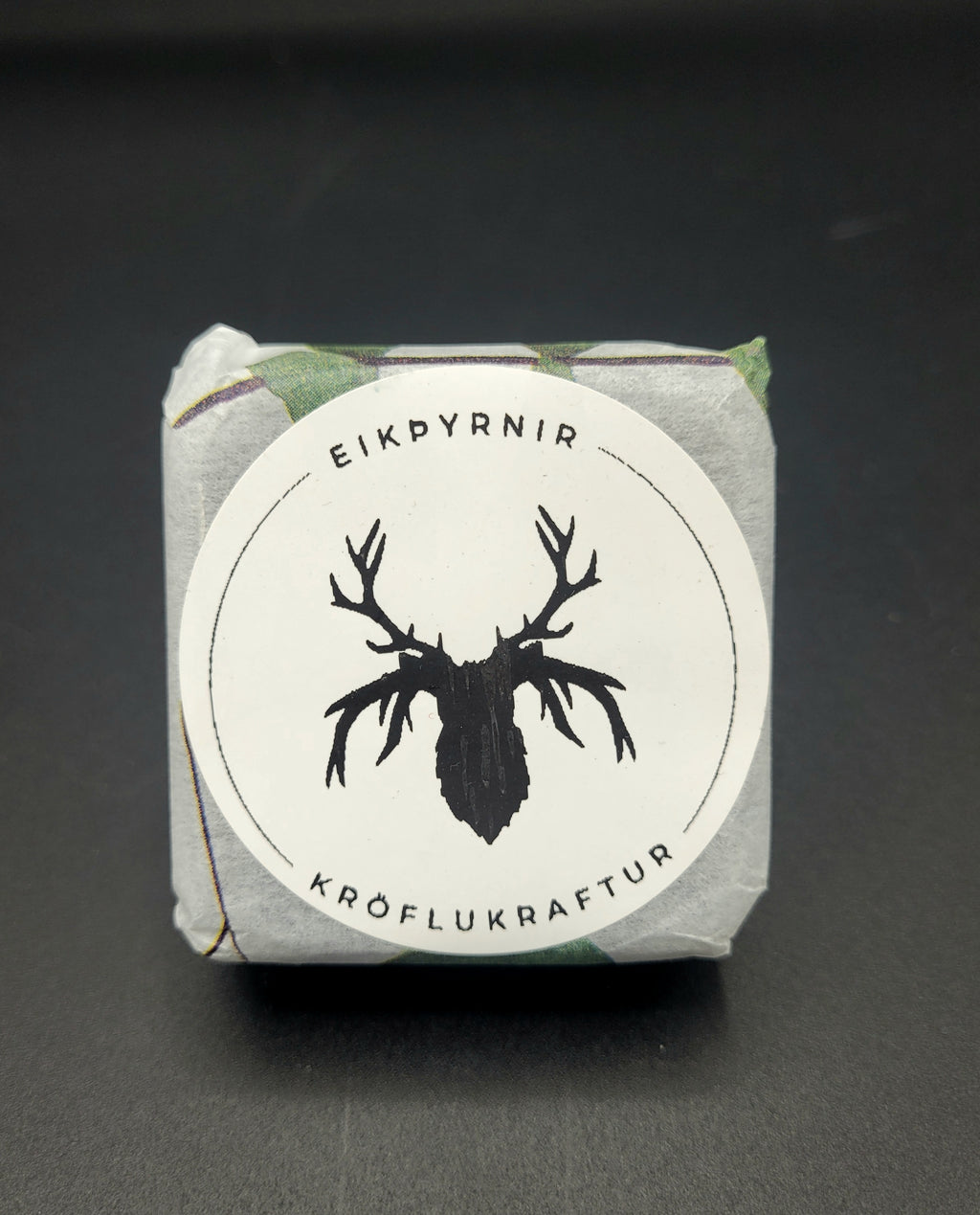 Product packaging with a deer silhouette logo and text on a dark background
