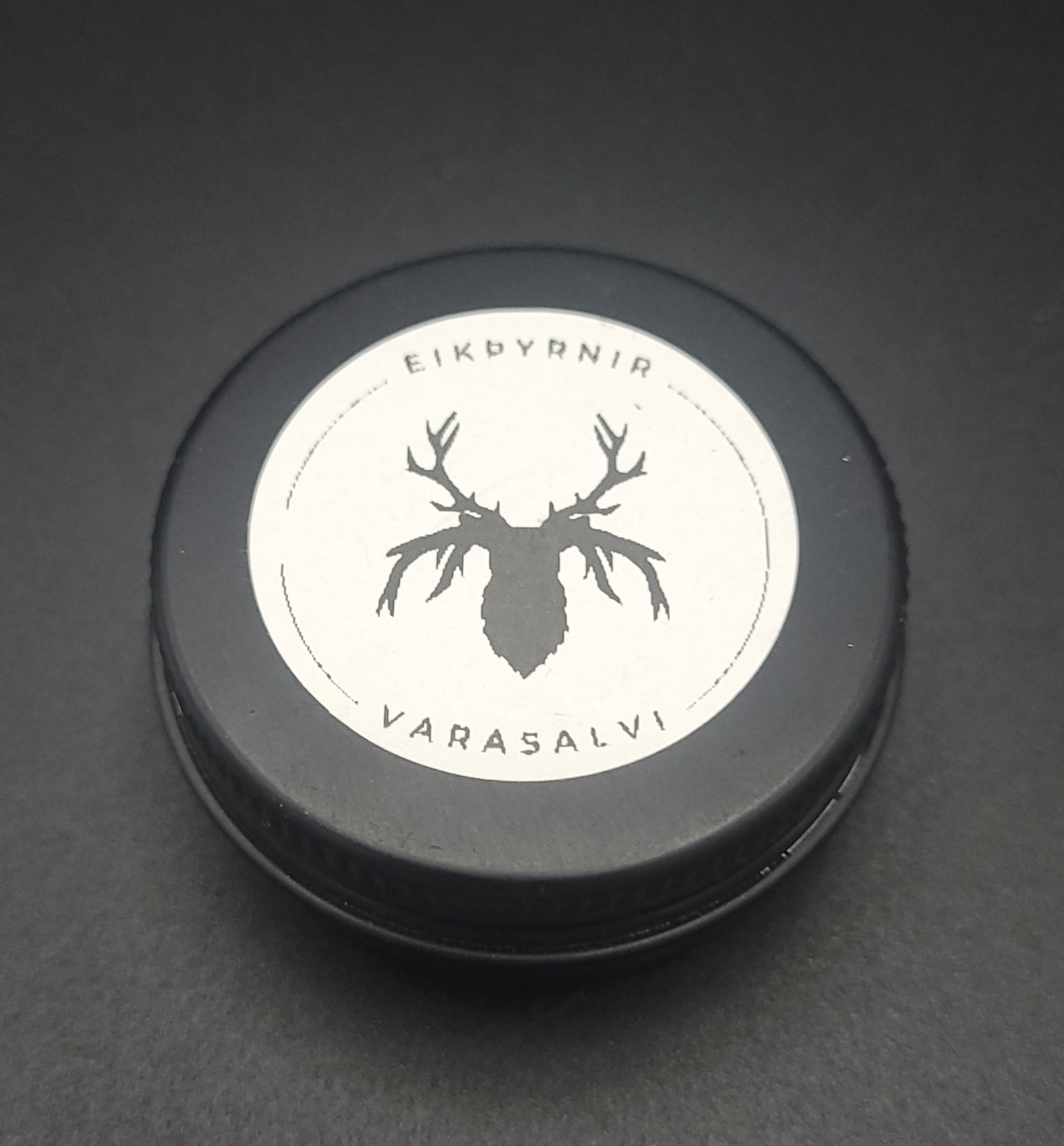 Black container lid with white label featuring a deer silhouette and text on a dark background