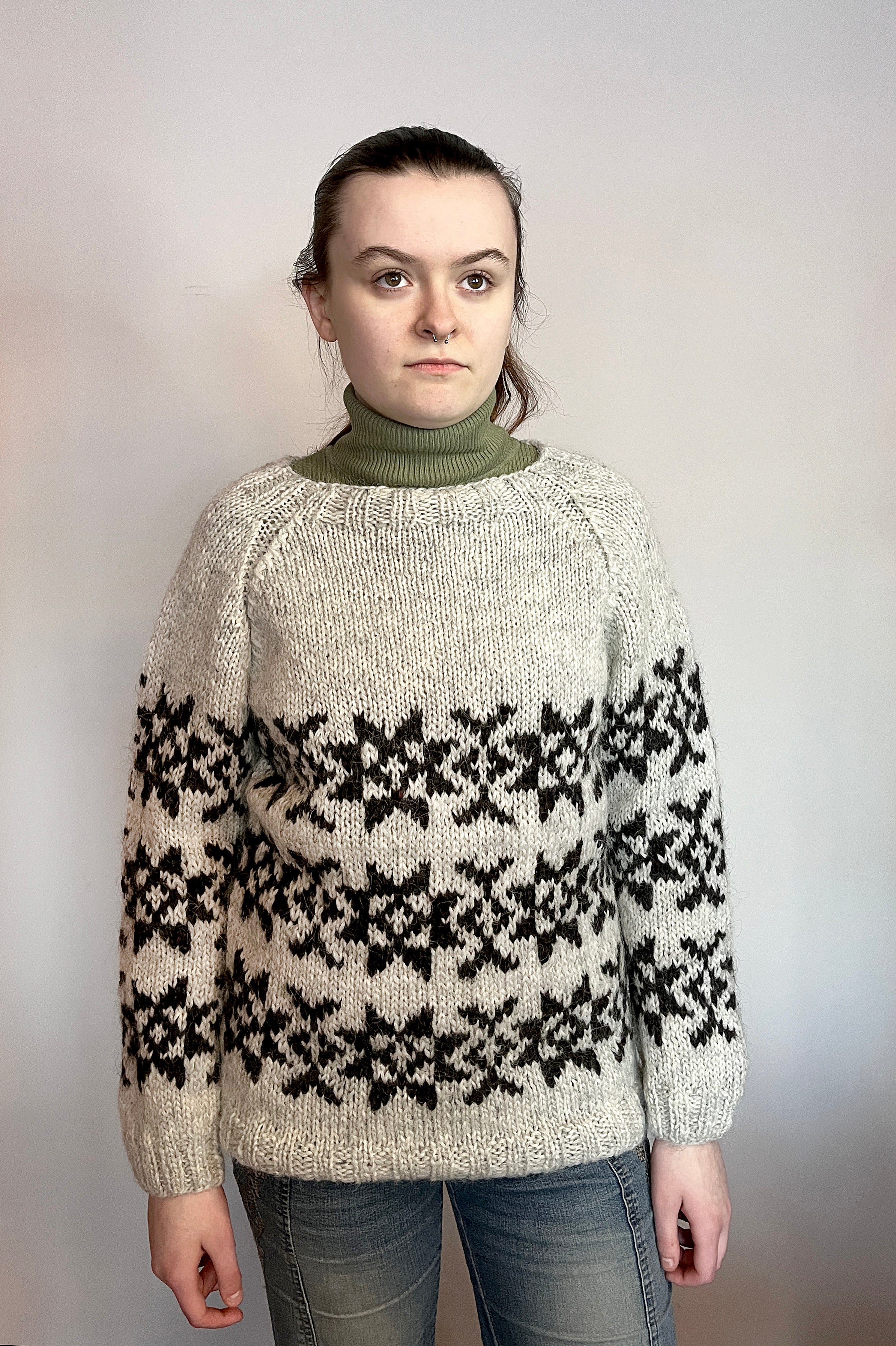 Woman in a hand knit Icelandic wool sweater featuring traditional Faroese knitting patterns.