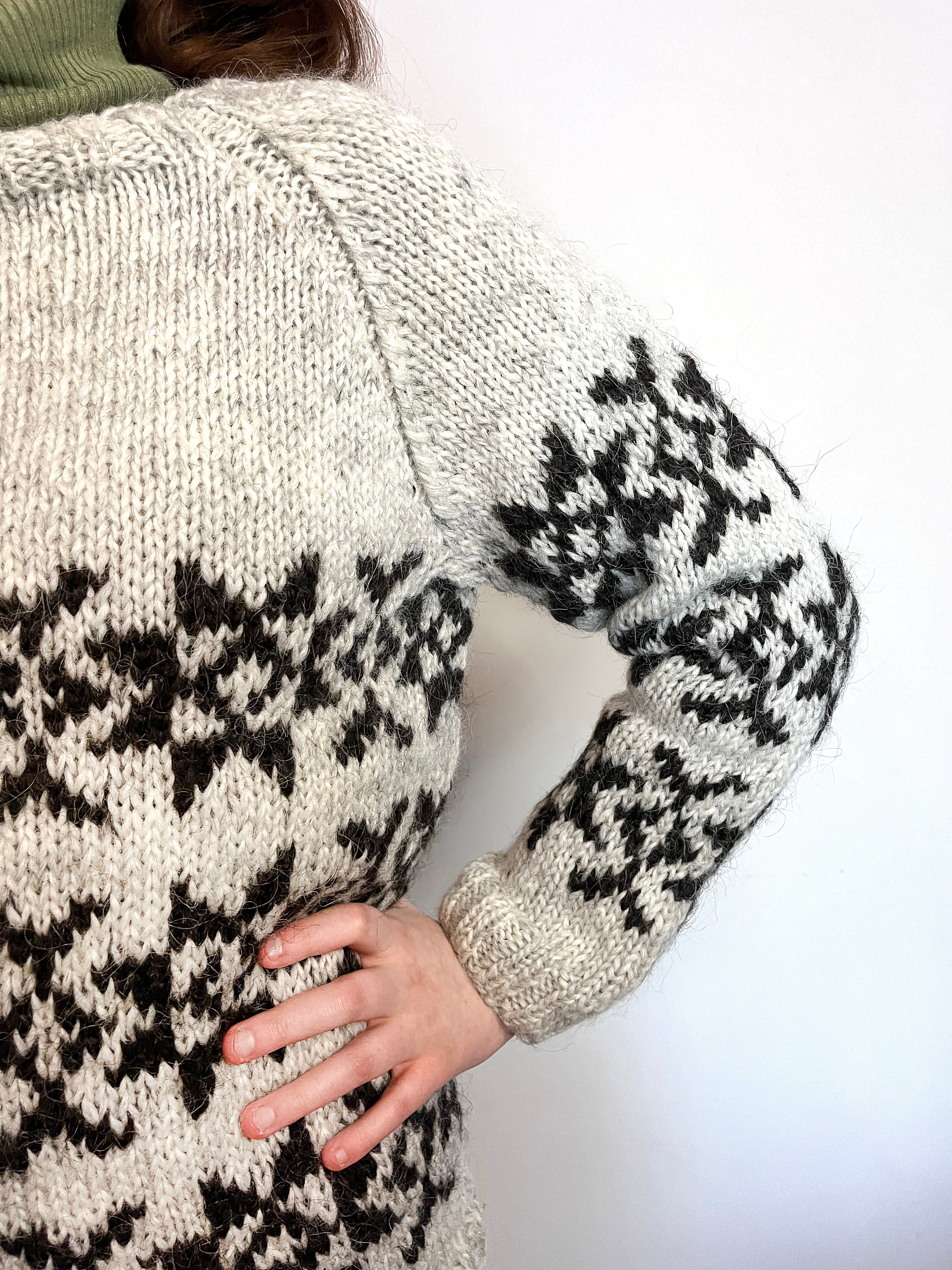 A close-up of a hand knit Icelandic wool sweater featuring traditional Faroese knitting patterns.