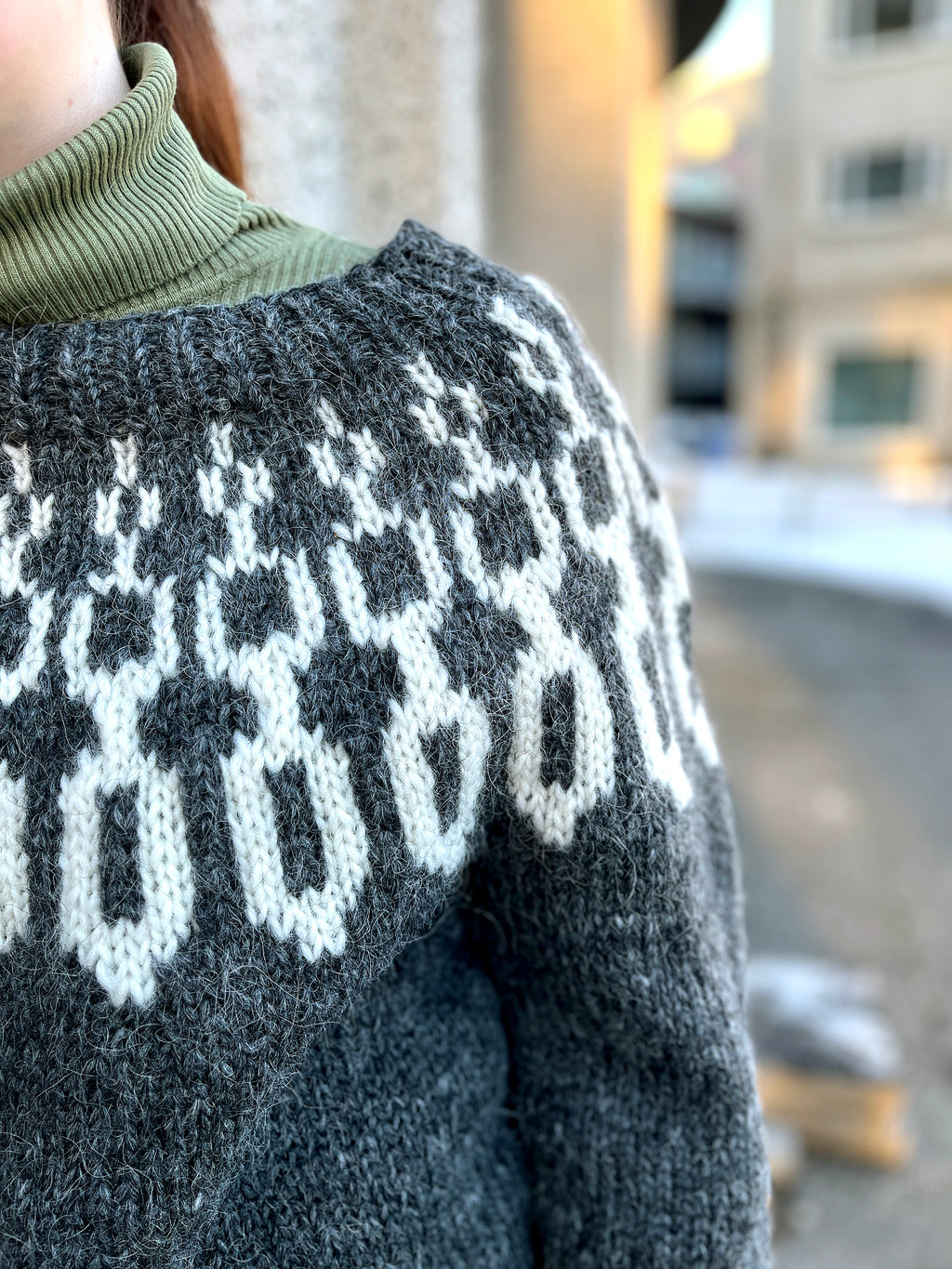 Close-up of a hand knit Icelandic wool sweater featuring a traditional nordic pattern that resembles chains