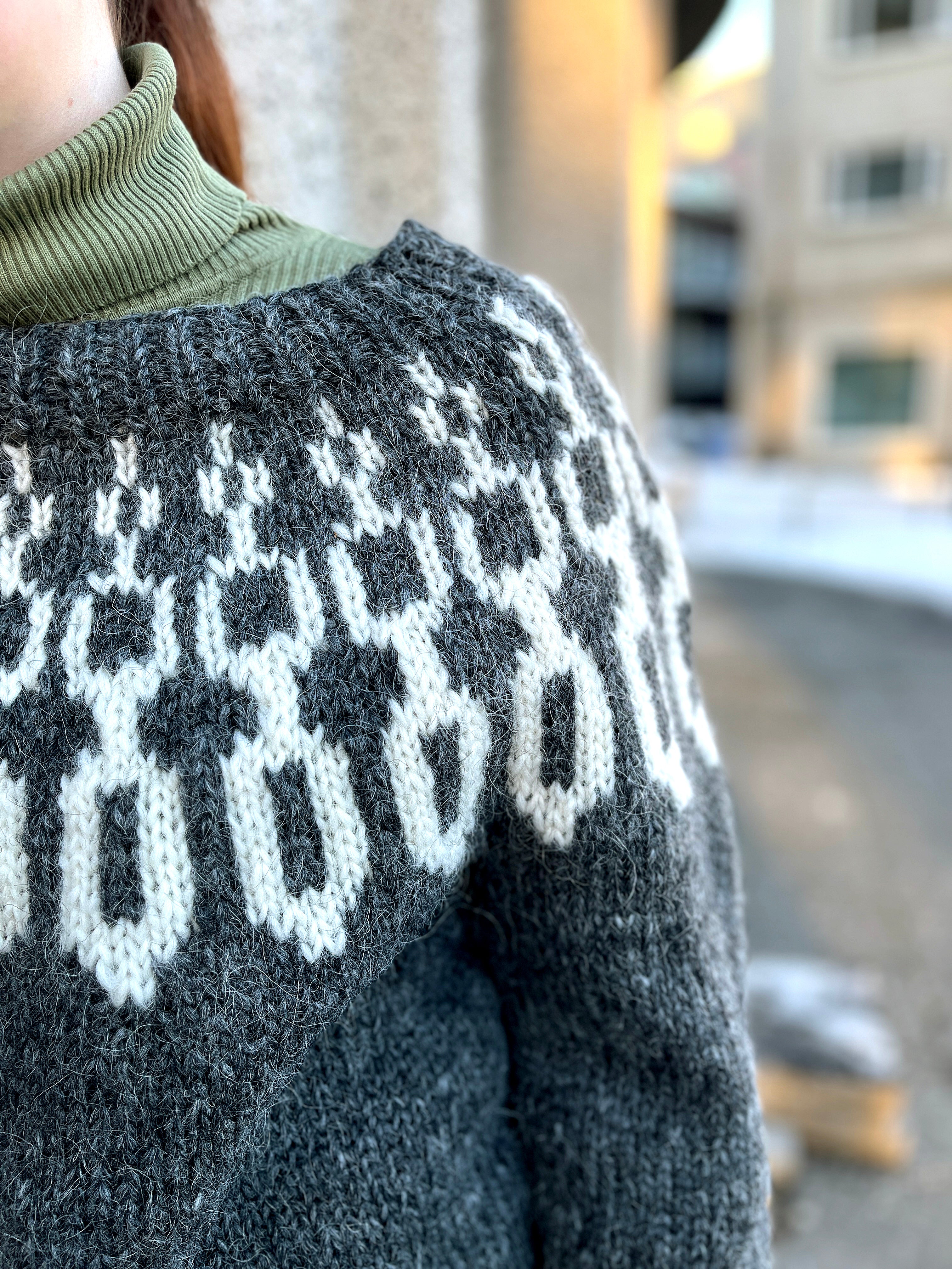 Close-up of a hand knit Icelandic wool sweater featuring a traditional nordic pattern that resembles chains