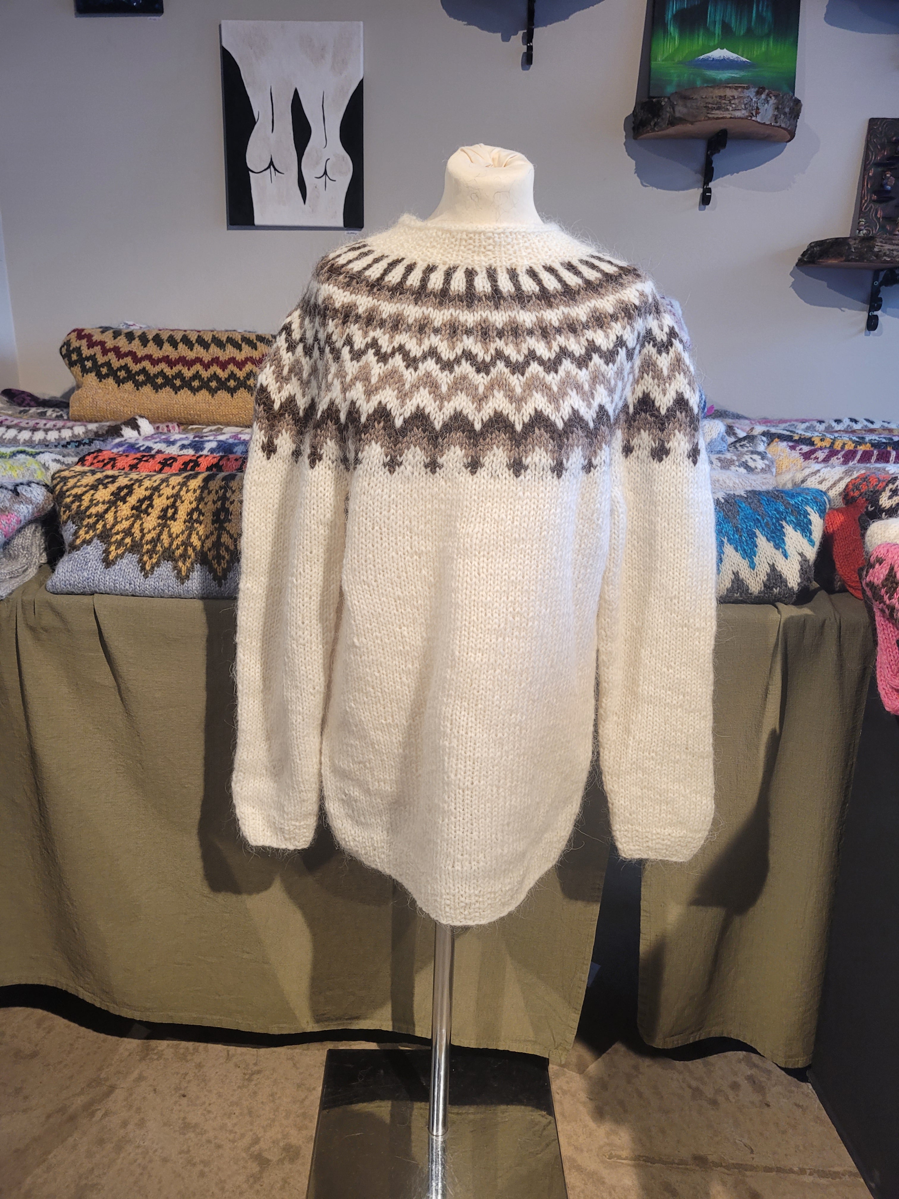 White Icelandic wool sweater with patterned cuffs on a mannequin.