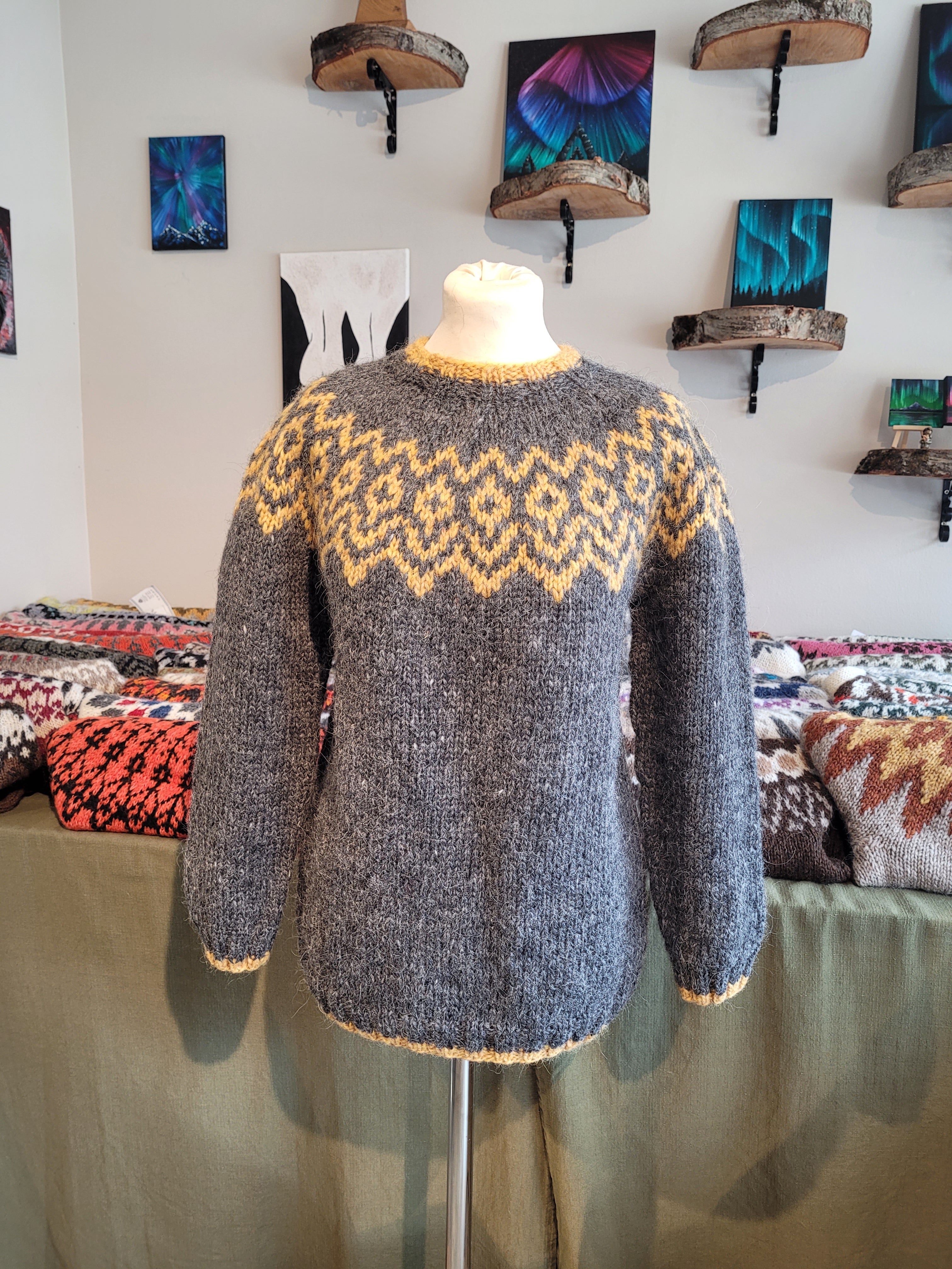 Mannequin wearing a patterned Icelandic wool sweater with a colorful background