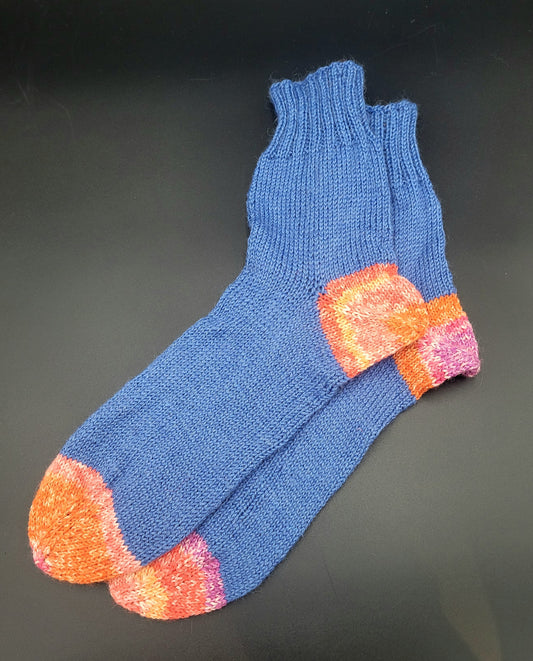 Blue sock with orange and pink accents on a dark gray background