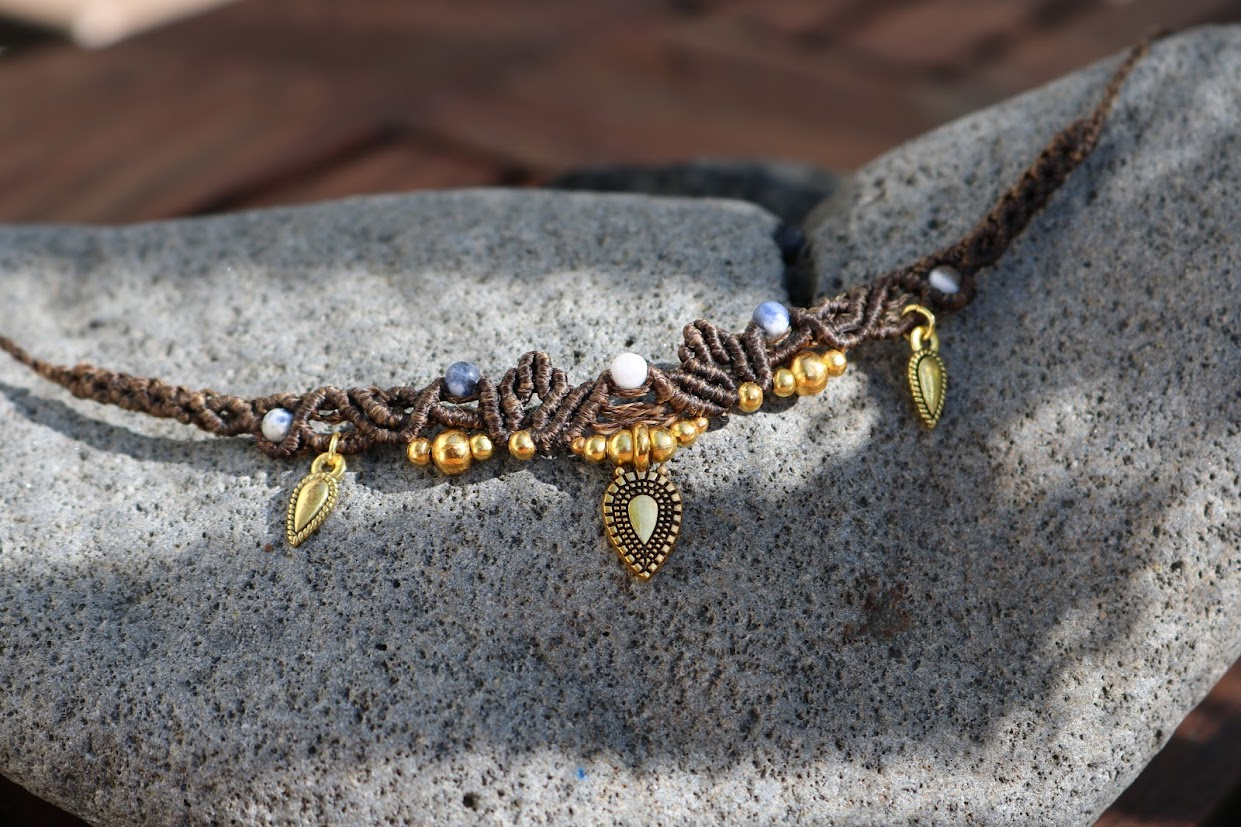 Necklace with beads and charms on a stone surface