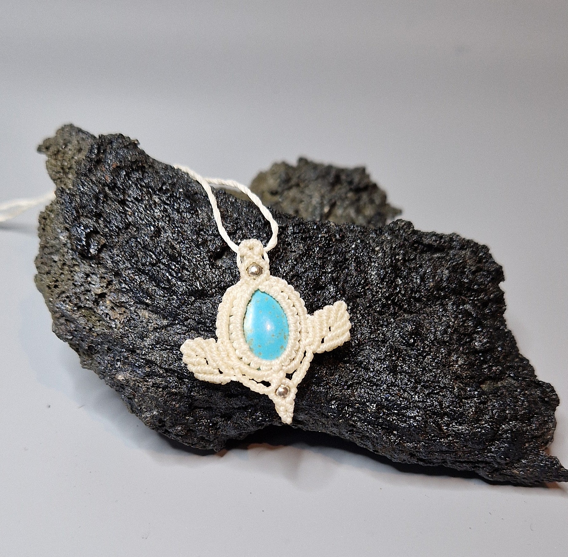 Pendant with turquoise stone on a dark rock background
