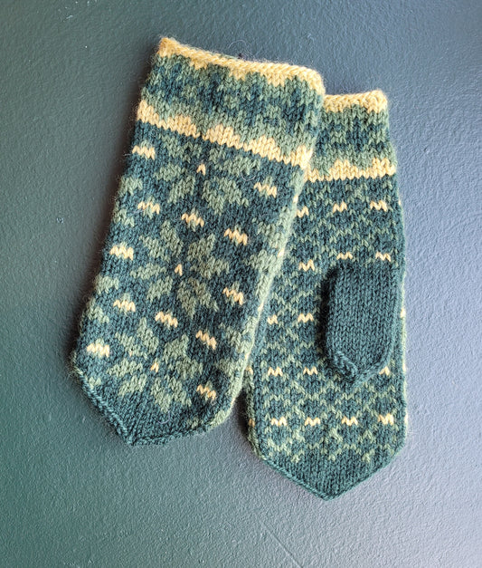 Green knitted mittens with traditional Icelandic pattern in lighter green and yellow on a dark green background