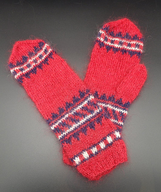 Red knitted mitterns with blue and white pattern on a dark background