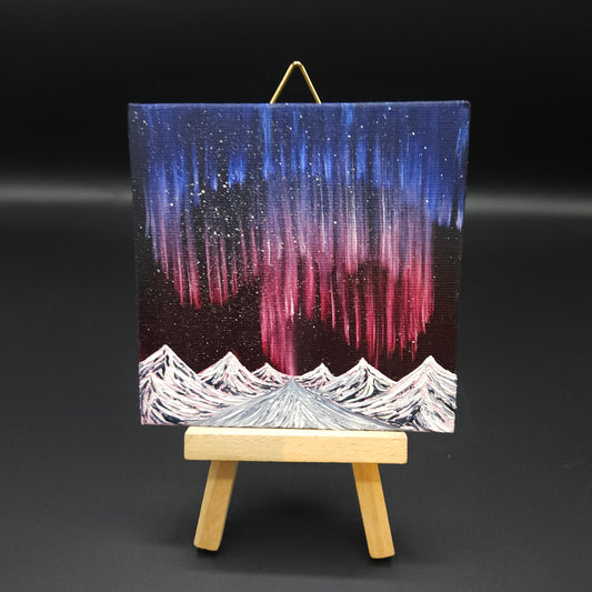 Northern lights landscape painting featuring purple and red northern lights over snow-capped mountains.