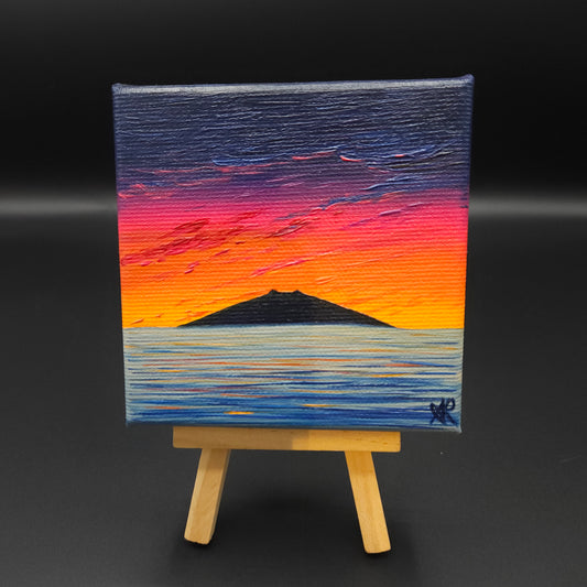 Landscape painting featuring a blue, red and orange sky and a mountain reflected in water.