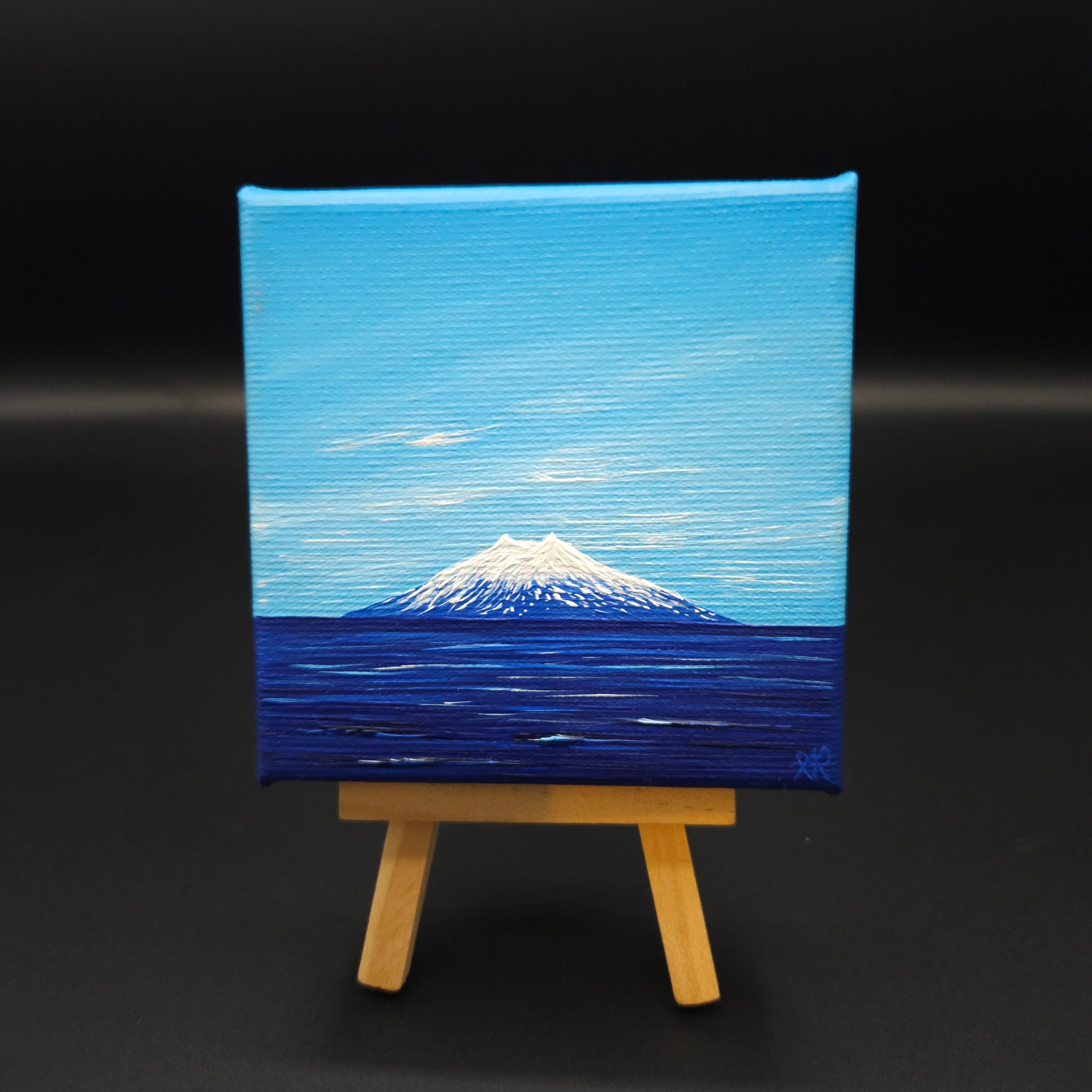 Abstract painting of a blue and white landscape on a black background