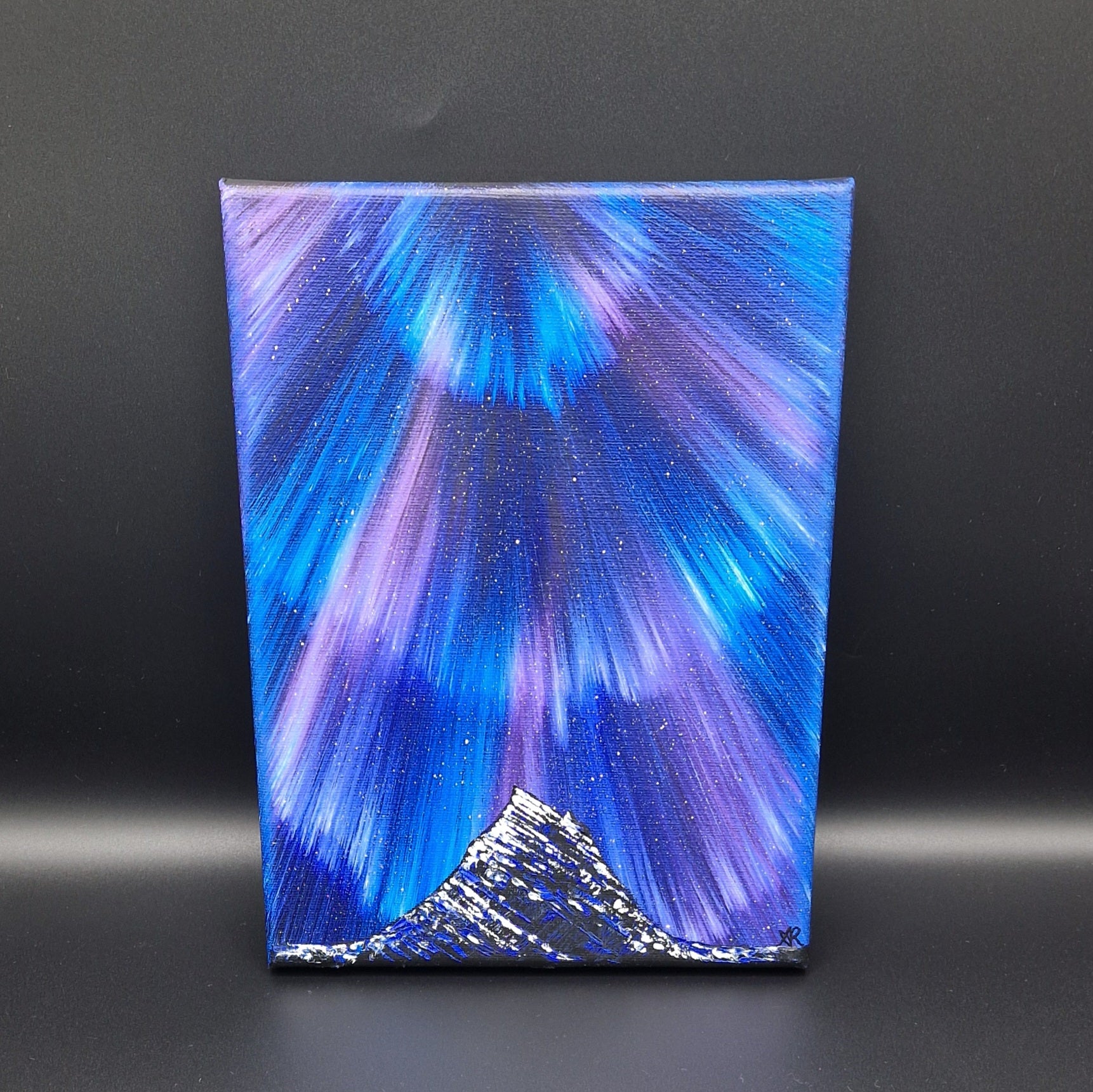 Blue and purple northern lights painting on a dark background