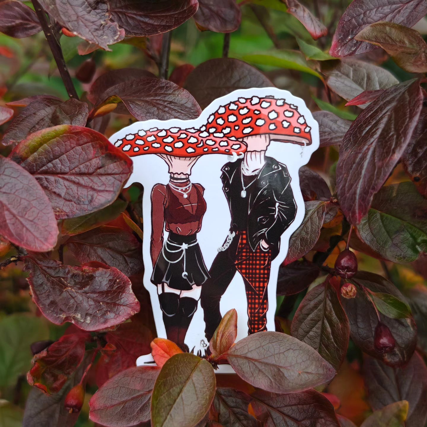 A decorative sticker depicting a cartoonish character with a large mushroom head, placed against a backdrop of red leaves.