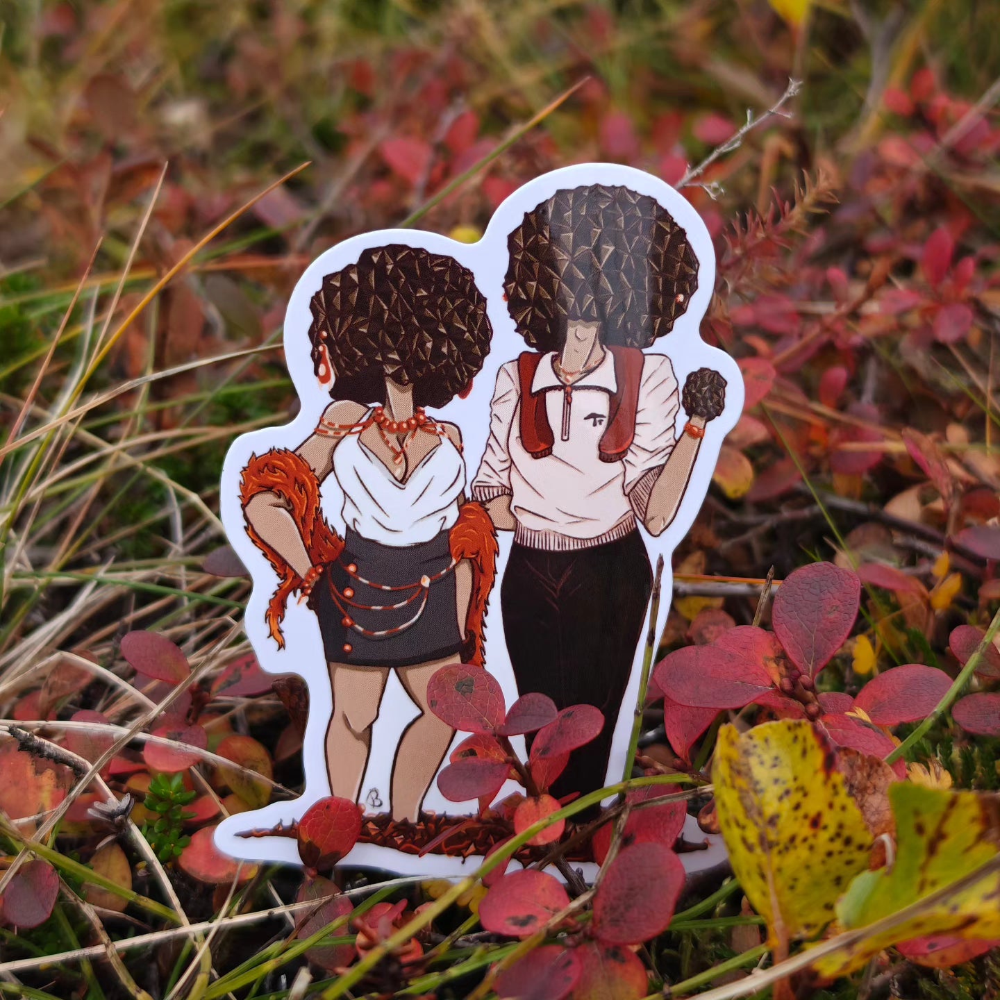 A vinyl sticker depicting two stylized mushroom characters with human features, dressed in vintage-style clothing, placed on a ground covered with red and brown leaves.