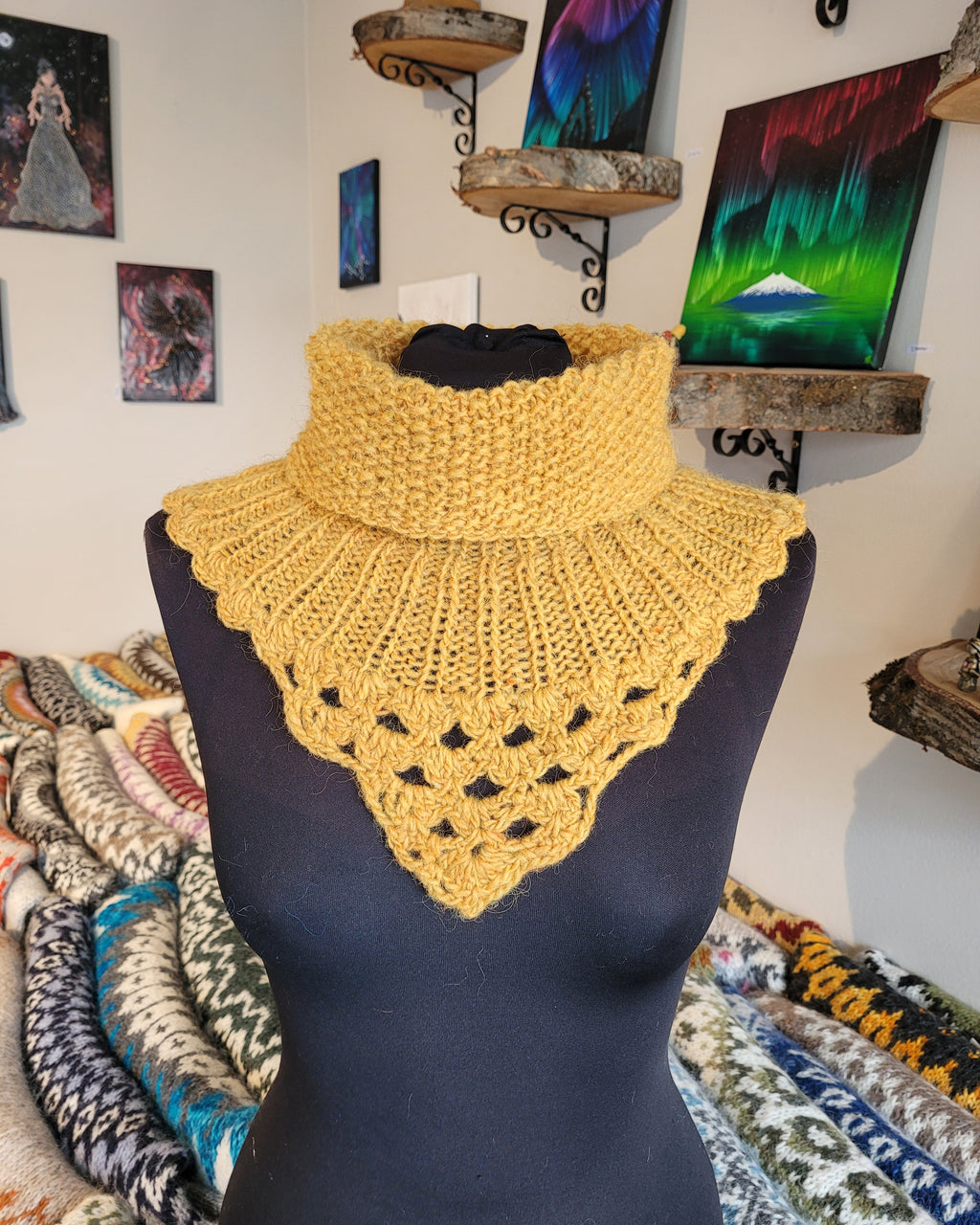 Yellow crochet and hand-knit collar on a mannequin with colorful art in the background