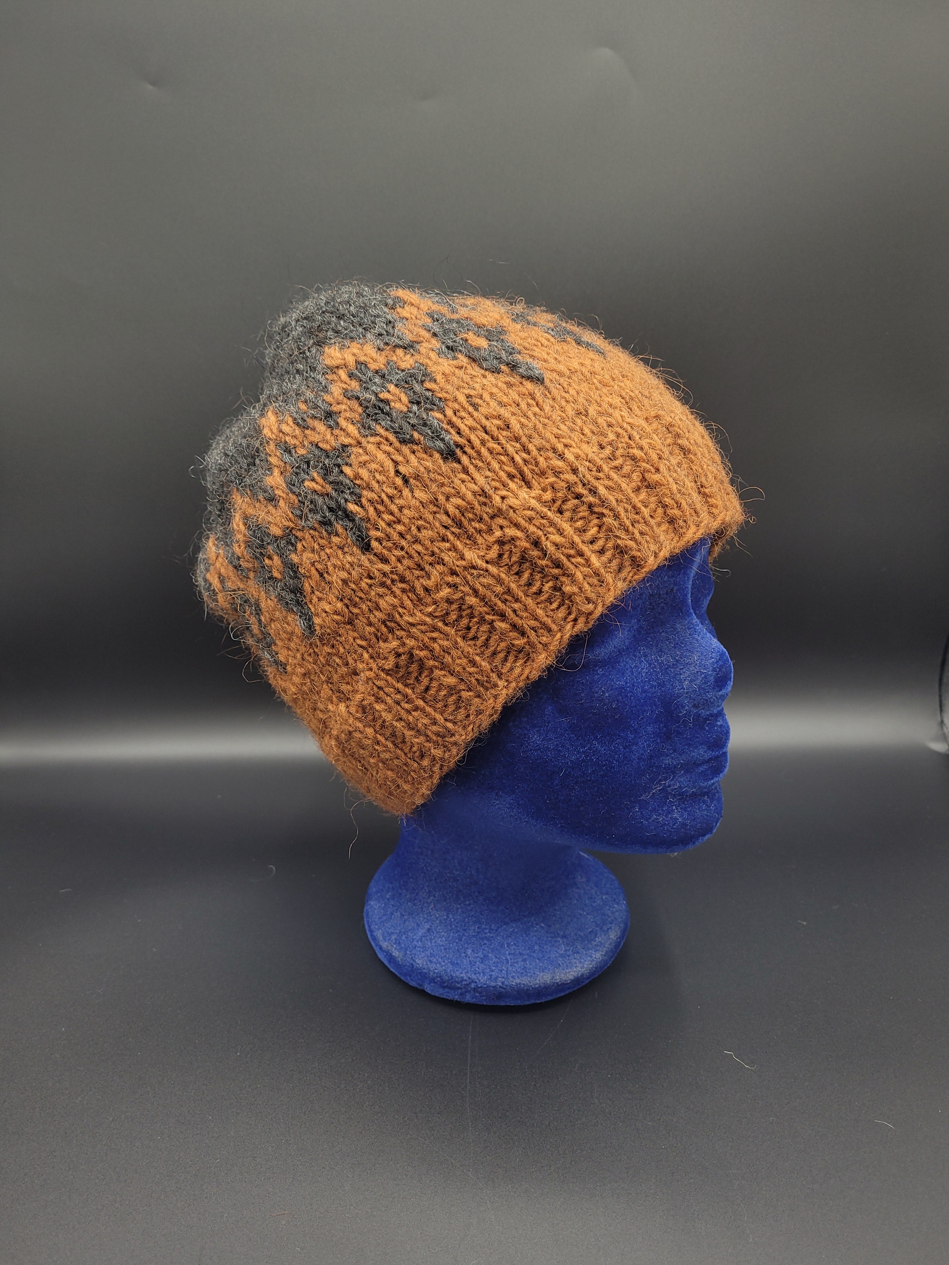 Knitted brown and blue hat on a black surface