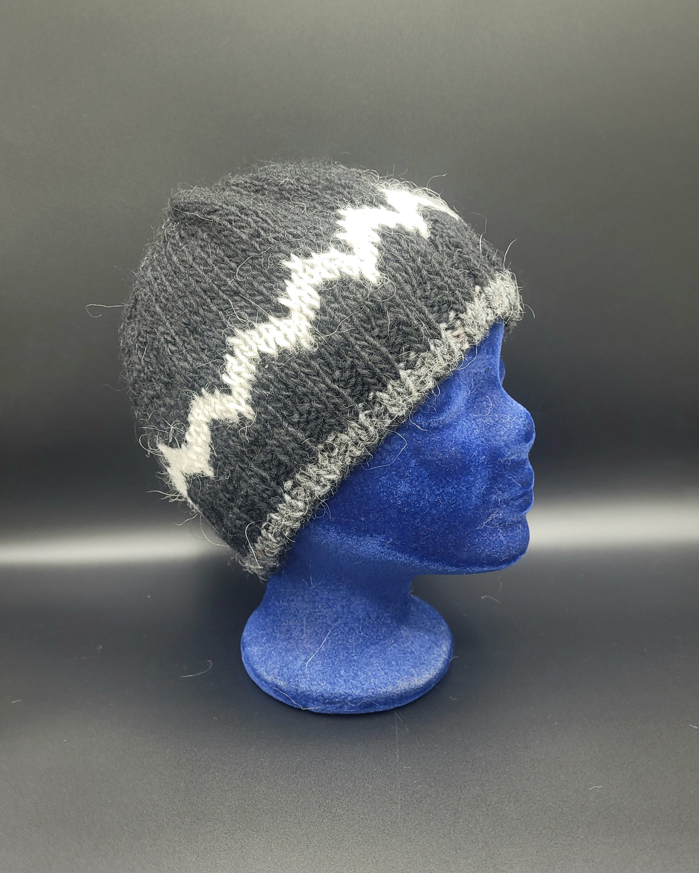 Gray knit beanie with white pattern on a blue mannequin head against a gray background